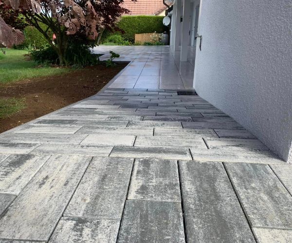 Chemin d’accès extérieur en pente revêtu de carreaux menant à la terrasse à Mamirolle, type accès PMR