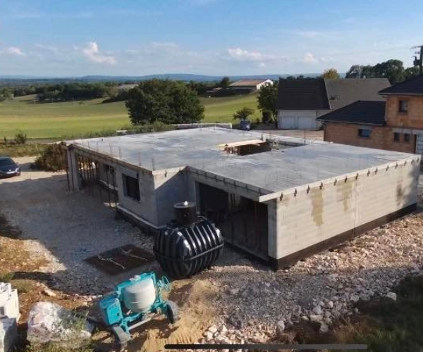 Maison en construction avec dalle supérieure coulée et cuve installée à Foucherans