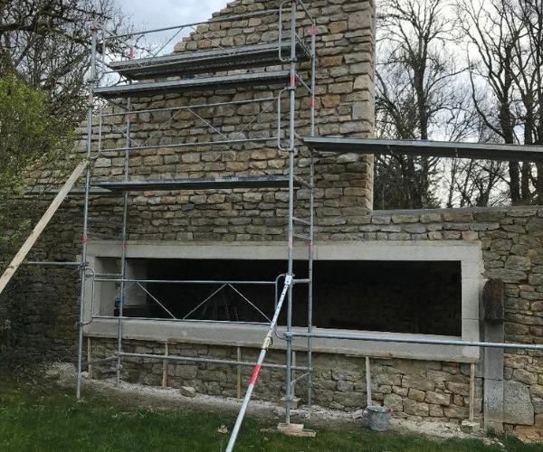 Rénovation d’un mur en pierre avec échafaudage à La Vèze