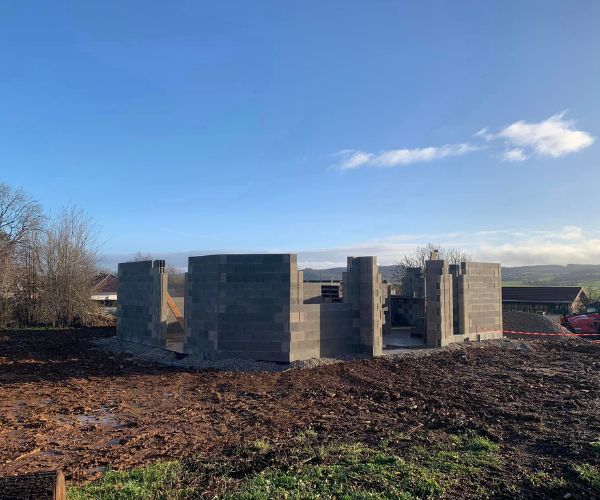 Élévation des premiers murs en parpaings pour une maison neuve à Mérey-sous-Montrond
