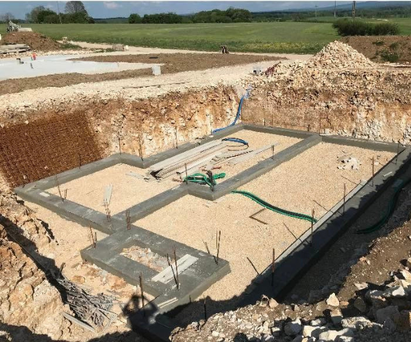 Fondations avec semelles filantes et réseaux en cours de pose pour une maison à Foucherans