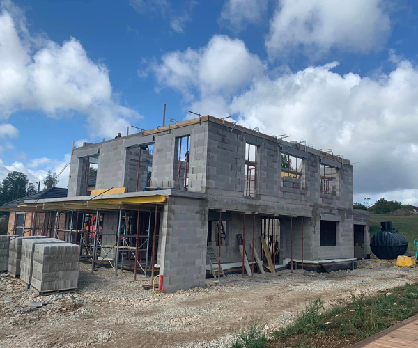 Construction du gros œuvre d’une maison avec échafaudages à Foucherans