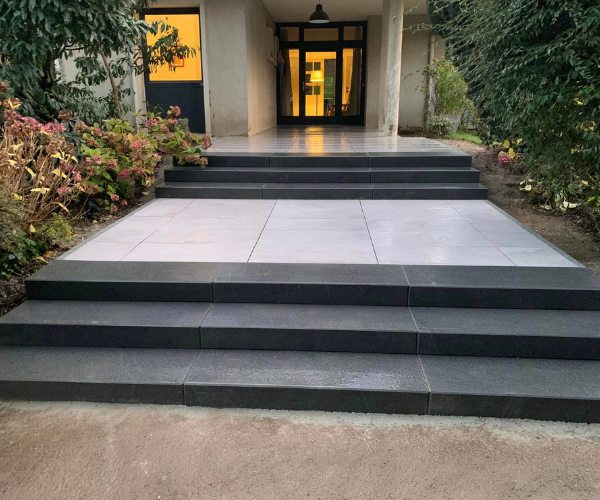 Terrasse carrelée et escalier en granit dans un jardin à Besançon