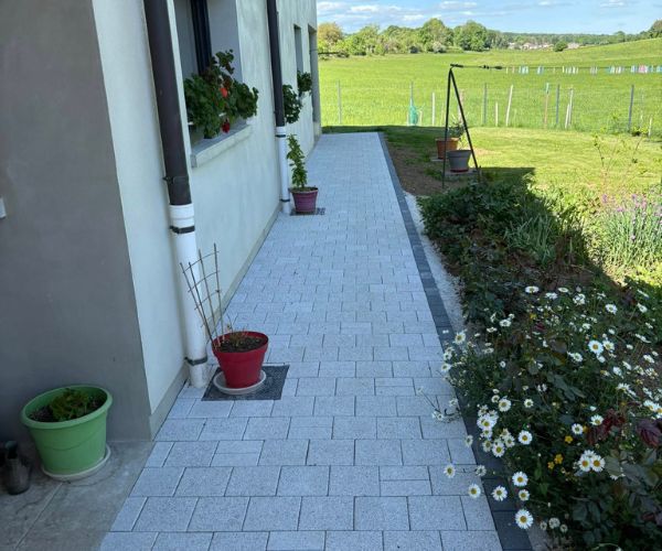 Zone pavée avec pavés Birkenmeier incluant un raccord technique discret.