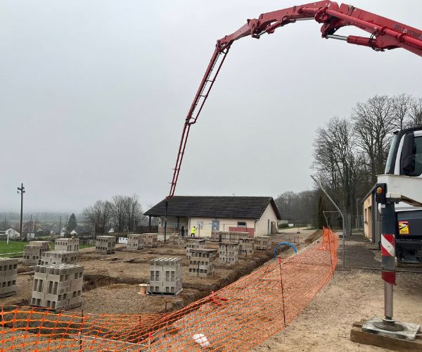 Pompe à béton et blocs béton sur chantier à Perrouse pour la construction des vestiaires de foot.