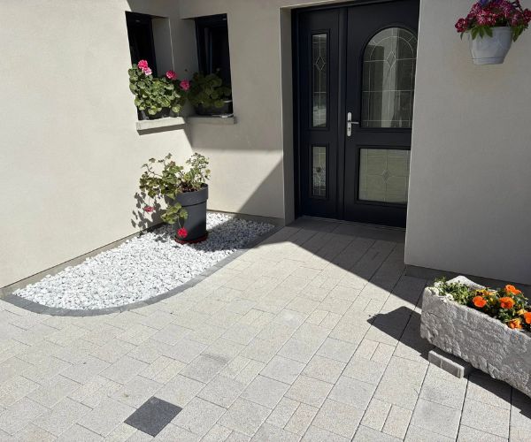 Cheminement extérieur pavé longeant une façade de maison à Trepot.