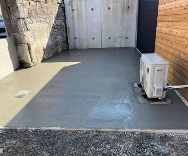 Dallage béton fraîchement coulé sur chantier à Quingey.