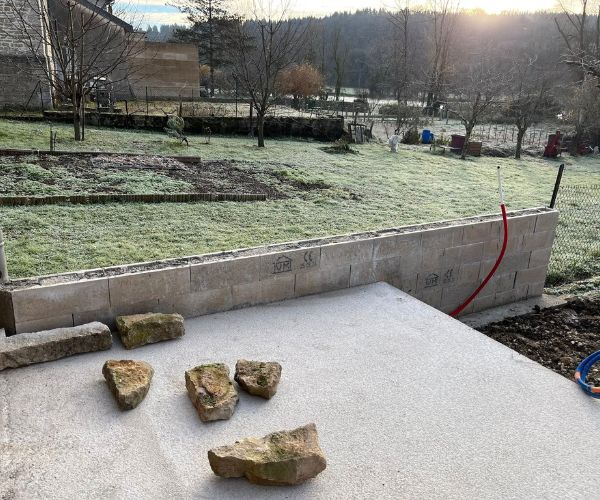 Dallage béton et premières pierres en place à Quingey.