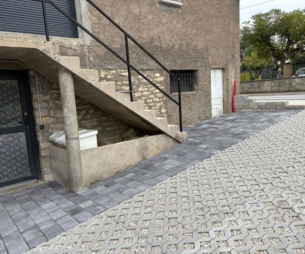 Accès latéral en pavés gris devant une maison à Grandfontaine.